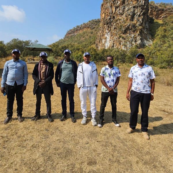 The Firstfield team in front of a rock cliff